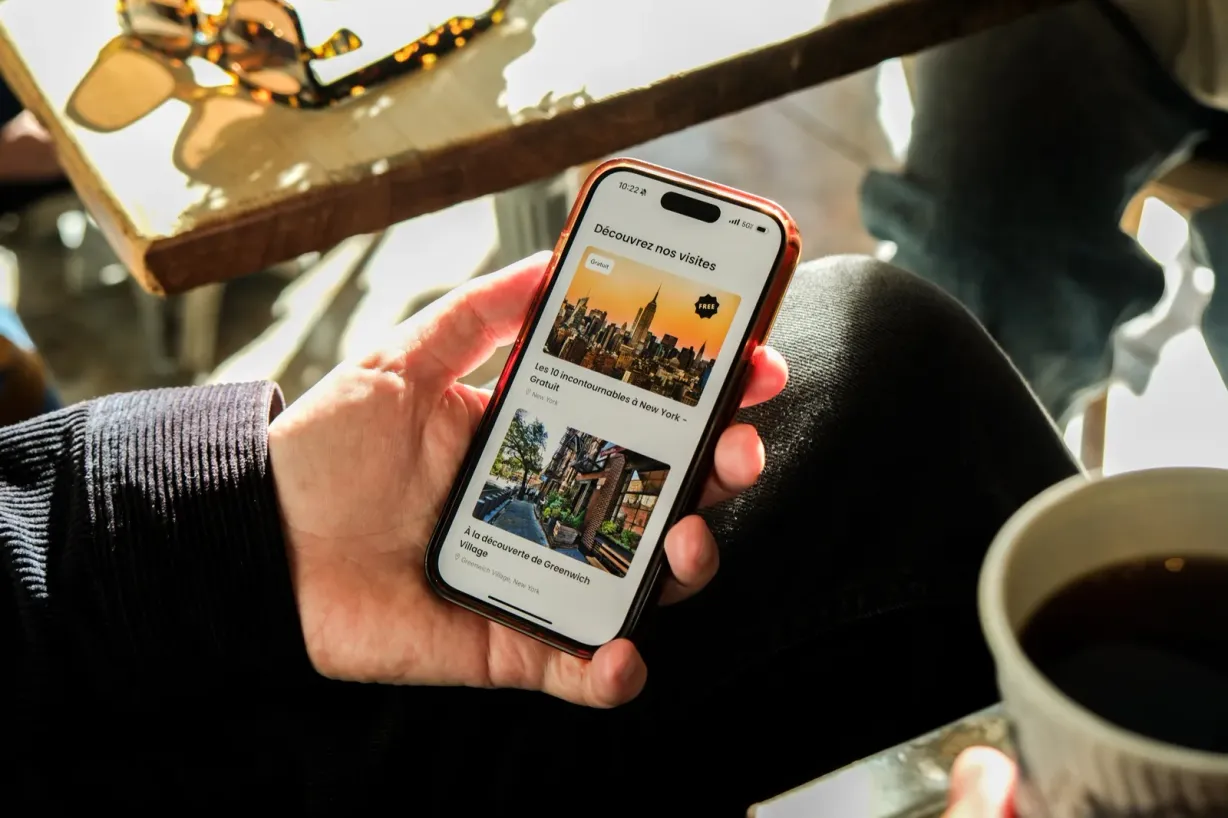 Une voyageuse consulte les balades proposées par Elya sur son téléphone.