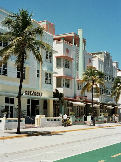 Façade Art déco pastel et palmiers à Miami Beach.