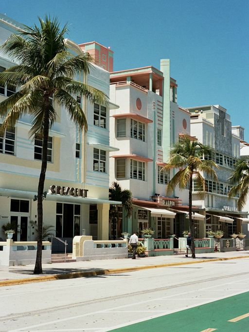 Façade Art déco pastel et palmiers à Miami Beach.